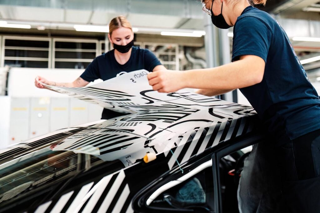 Two women applying wrap Audi assembly line