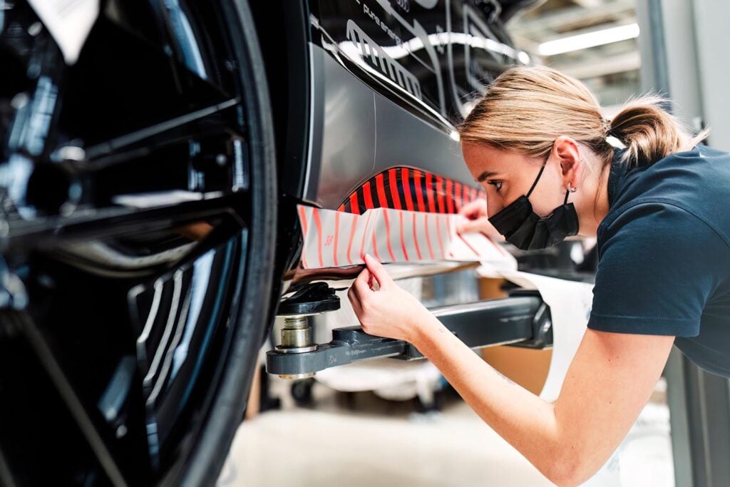 woman working on Audi assembly line