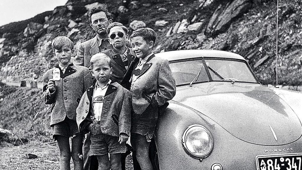 Black and white photo of group of people and car
