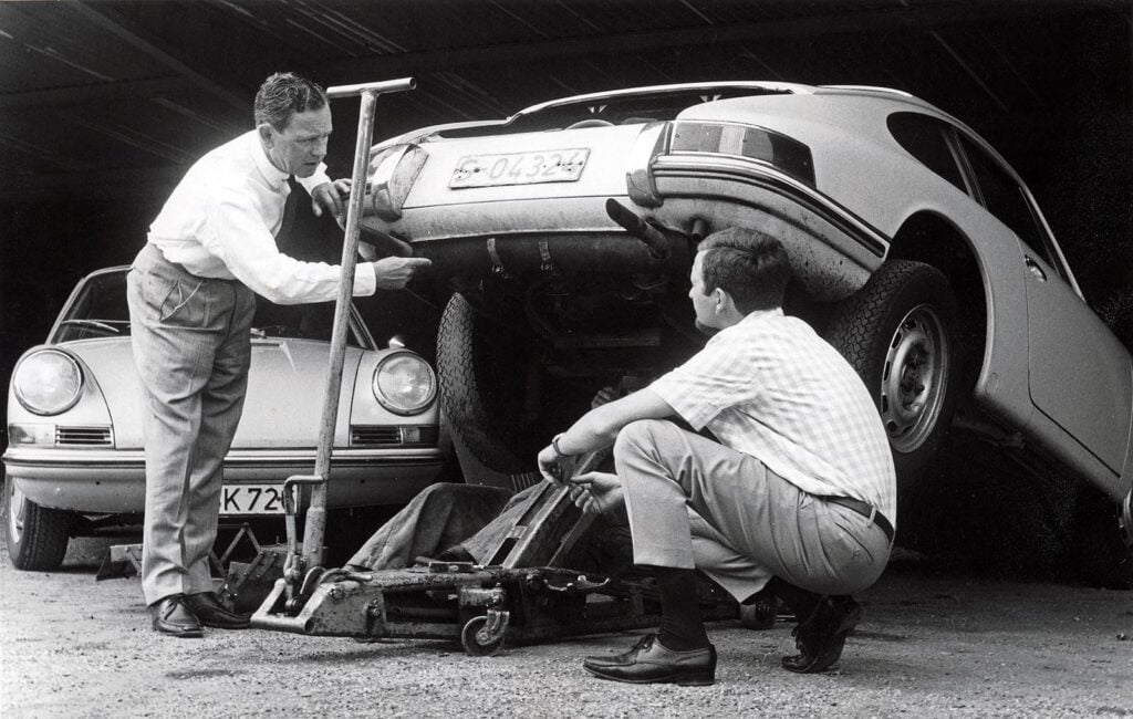 black and white photo of two men and a car
