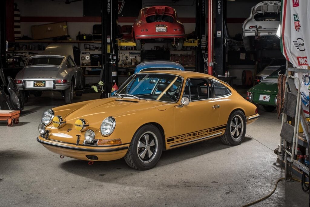 Golden yellow Porsche 912 vs 911 in a car garage