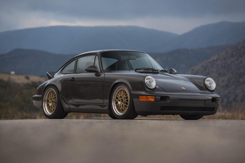 Grey Porsche on road mountains in background