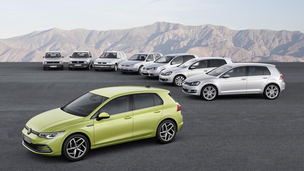 Green VW GTI in front of 6 generations of VW GTI's