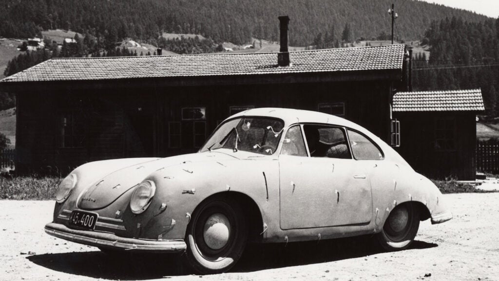 black and white photo of a car on dirt road