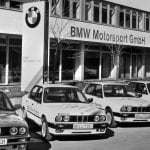 black and white photo of BMW vehicles in line