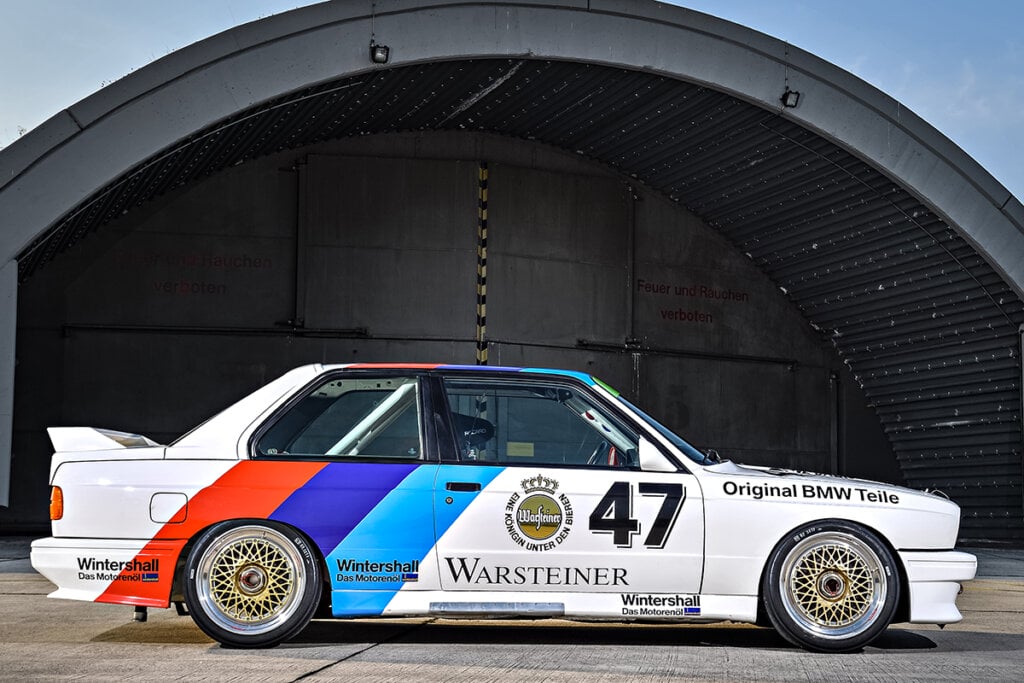 white bmw e30 m3 in front of warehouse