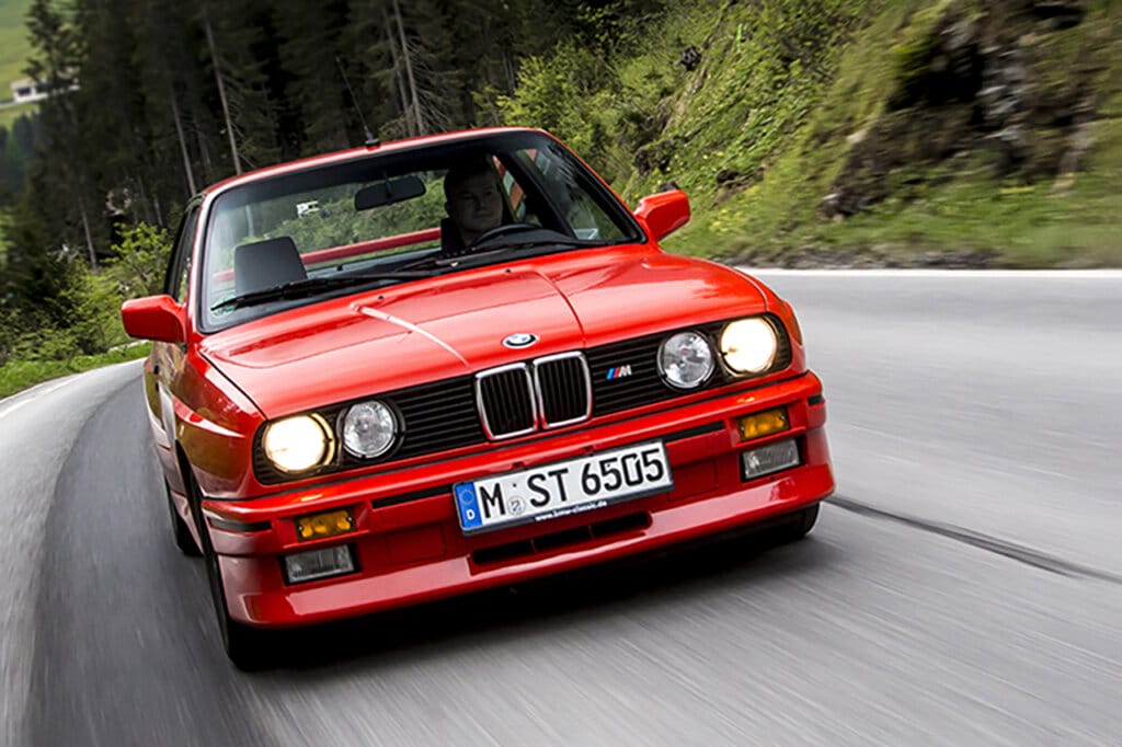 red e30 m3 driving on mountain road