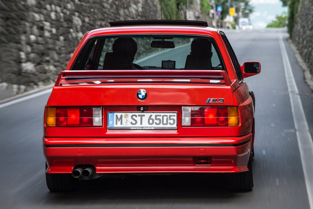 red BMW E30 M3 driving away