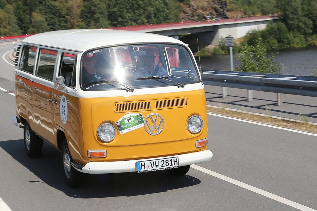orange VW Bus driving on highway