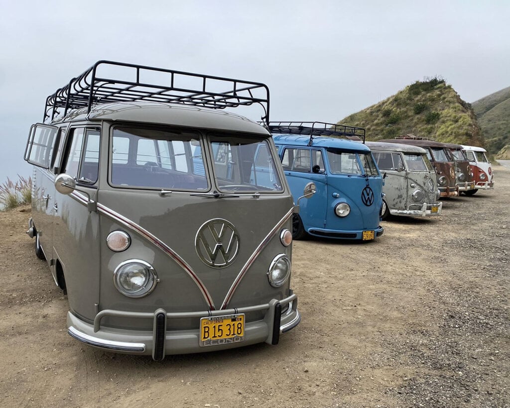 line of VW type 2 Buses on rocky road 