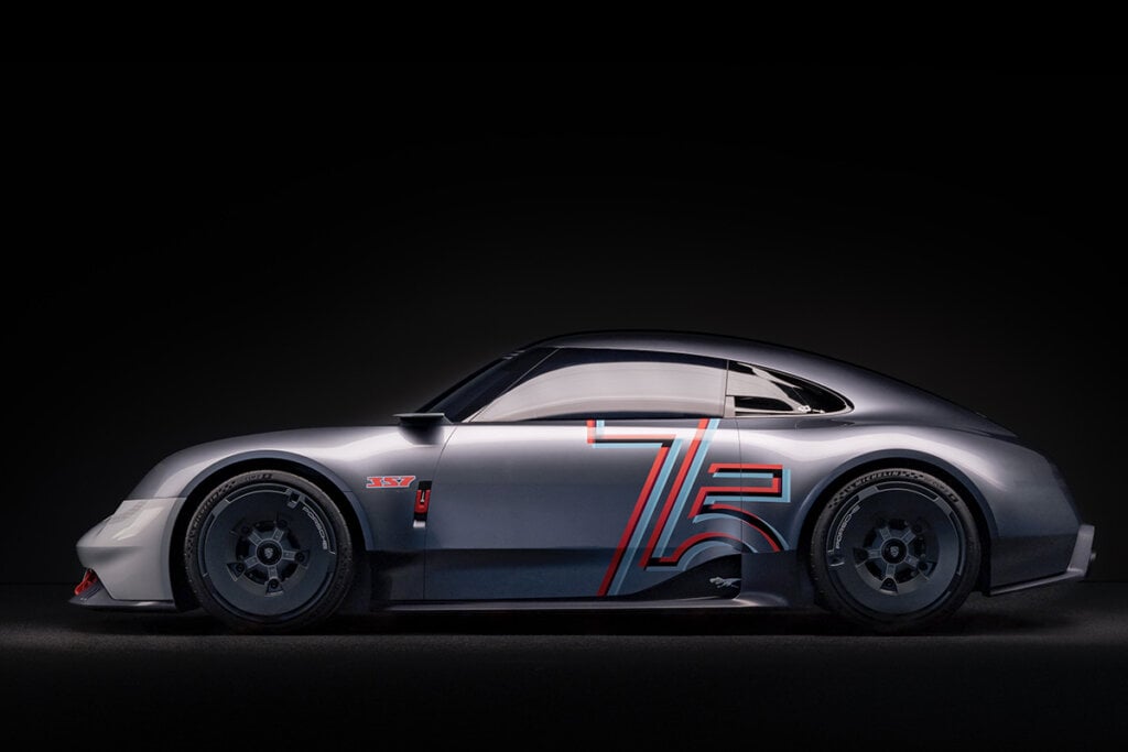 side profile of a Porsche 357 with 75th anniversary livery parked in a black room