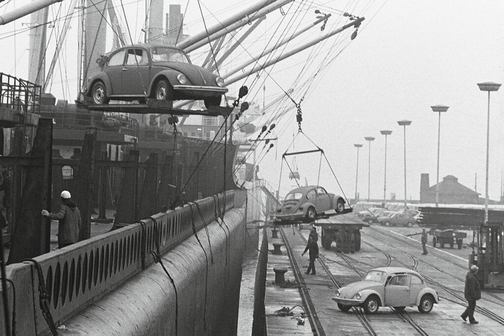 black and white photo of VW beetles offloading from ship