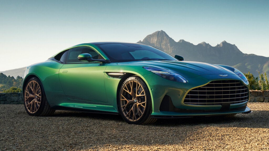 Green Aston Martin DB12 Super Tourer on a sandy beach