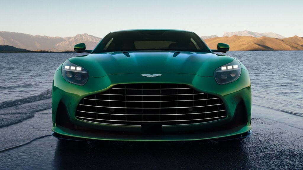 Front view of green Aston Martin on a road on the beach