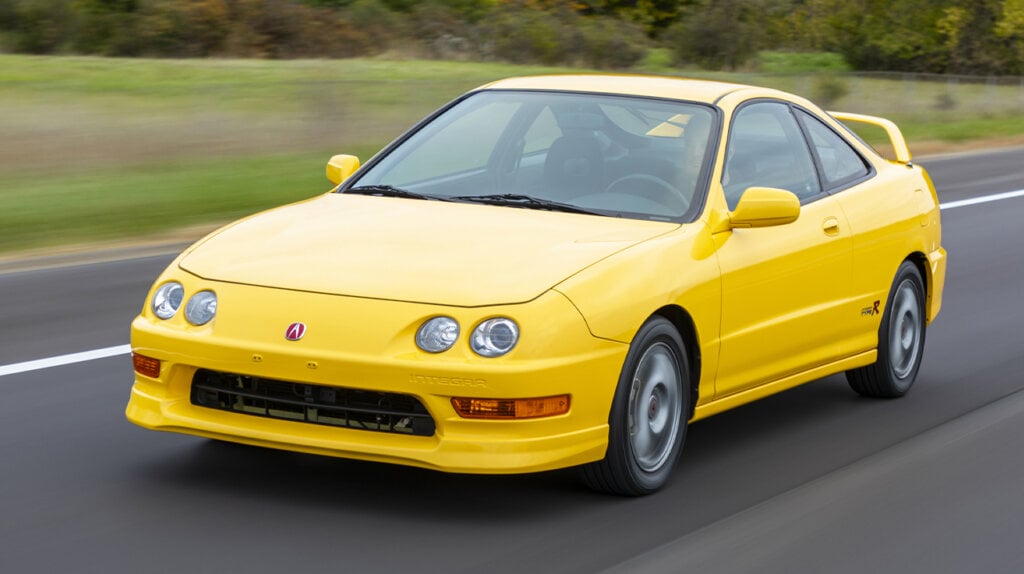 Yellow 2001 Acura Integra Type-R racing down a road
