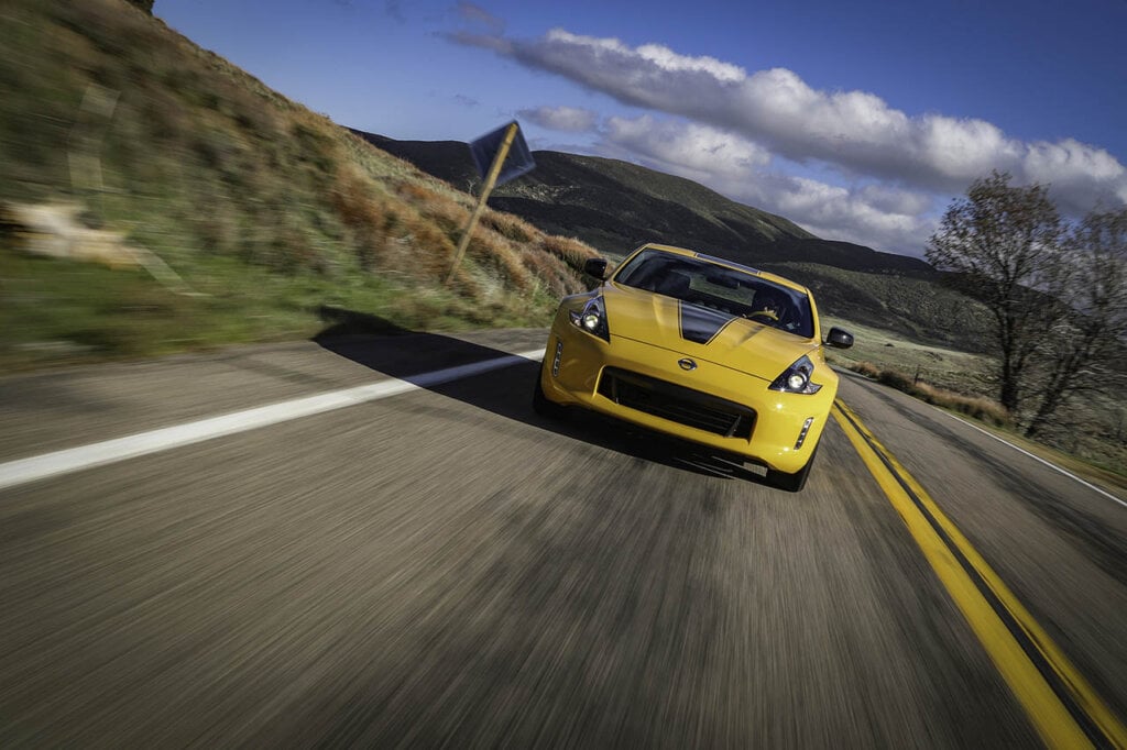 yellow 370z heritage edition speeding on a country highway