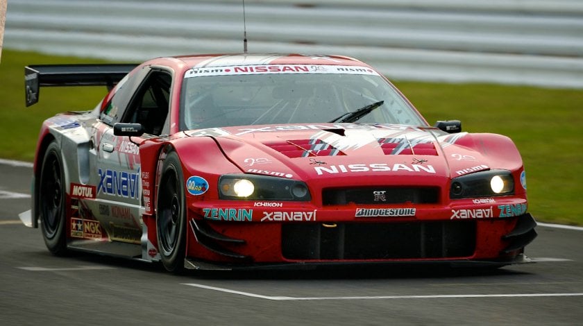 red and silver 2003 Xanavi NISMO Nissan Skyline GT-R racing on a race track