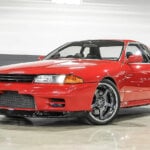 Red Nissan Skyline R32 parked in a showroom