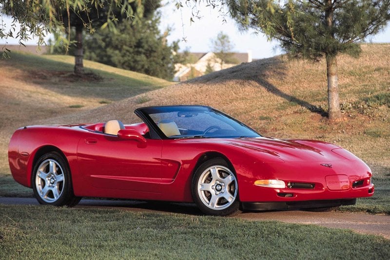 Red C5 Convertible parked near grass