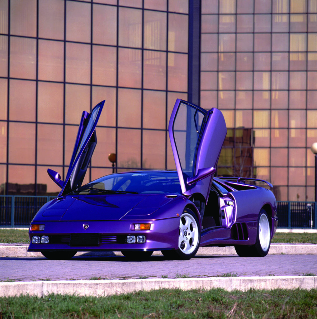 purple lamborghini diablo se30 next to business building