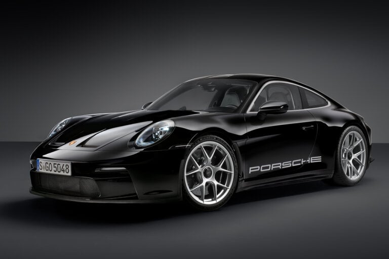 Black Porsche 911 R/T car on black background with chrome wheels and glossy paint