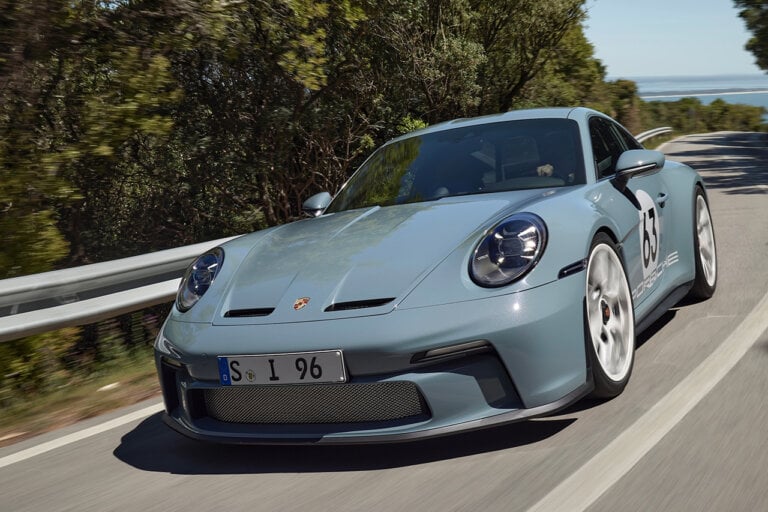 blue Porsche 911 st on road driving aggressively