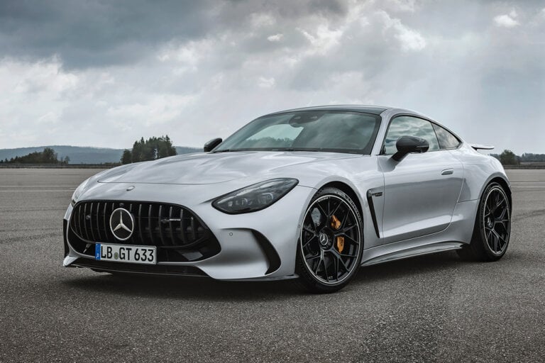 Silver Mercedes Benz AMG GT Coupe parked with cloudy sky behind it