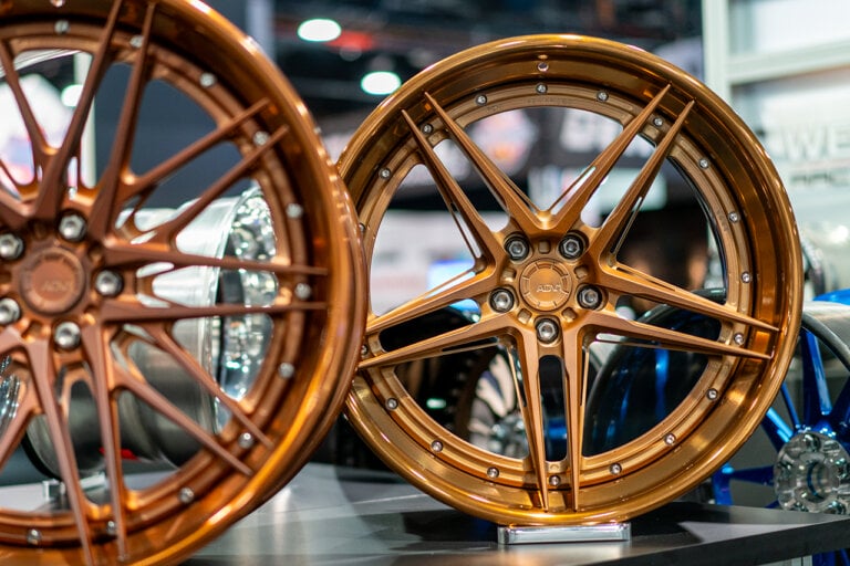 two bronze gold wheels next to eachother side by side in a showroom floor