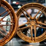 two bronze gold wheels next to eachother side by side in a showroom floor