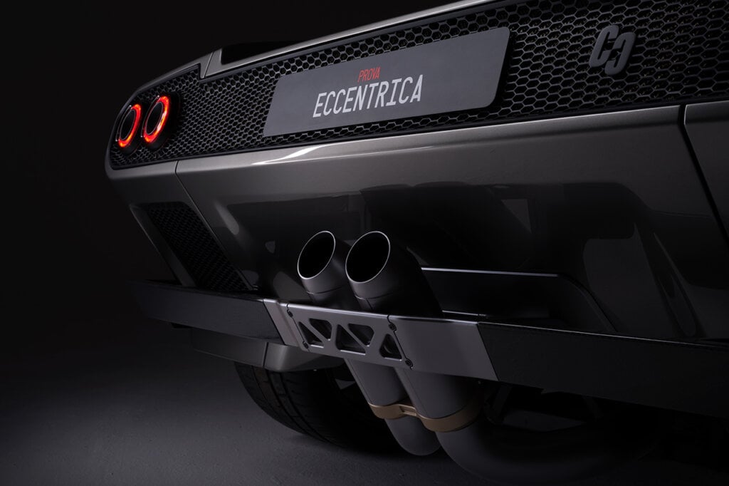 Rear side of the Diablo that has a name where the license plate goes. It says Eccentrica really dark background behind the car