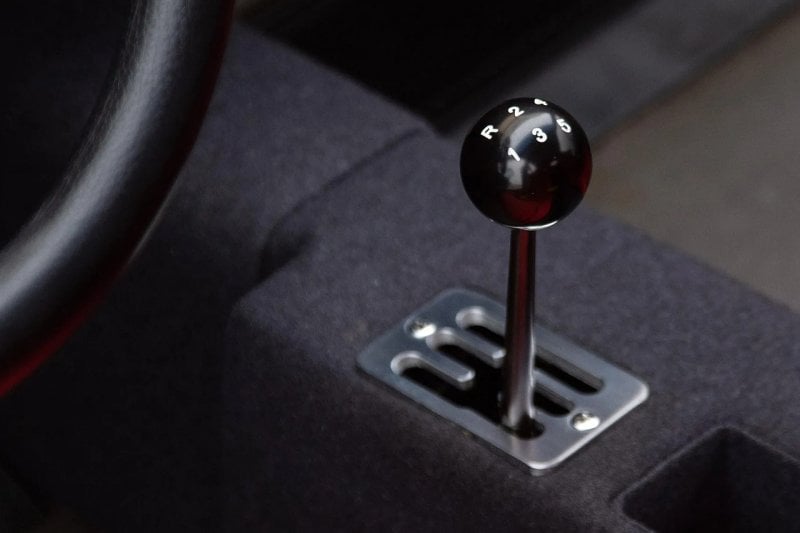 black gated stick shift in an F40, black knob with white letters and numbers on it