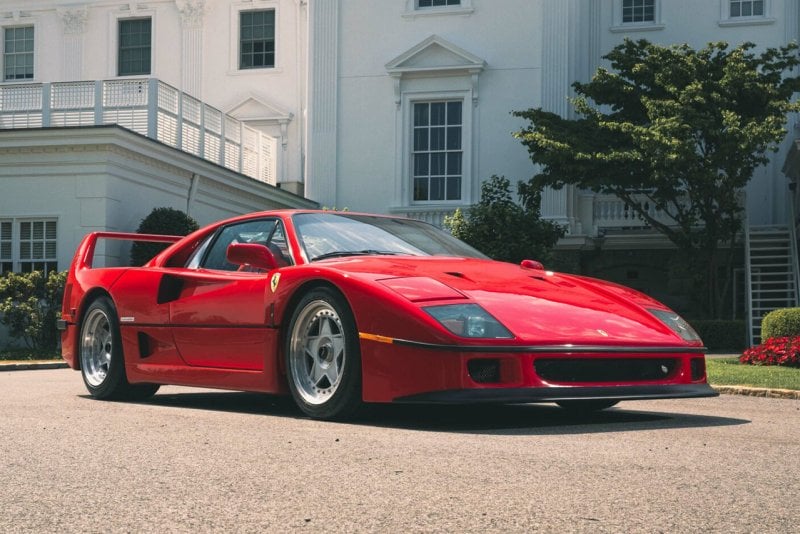 Red Ferrari F40 infront of a White House in the bright sunlight