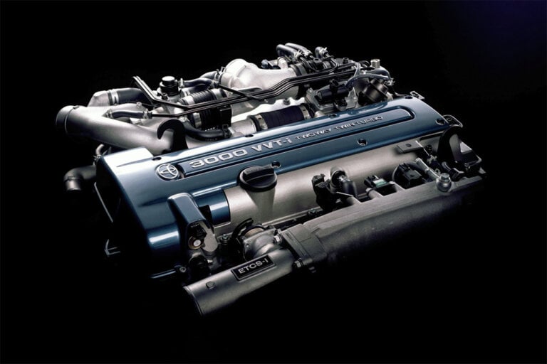 2JZ engine with a blue valve cover and the engine is on a solid black background