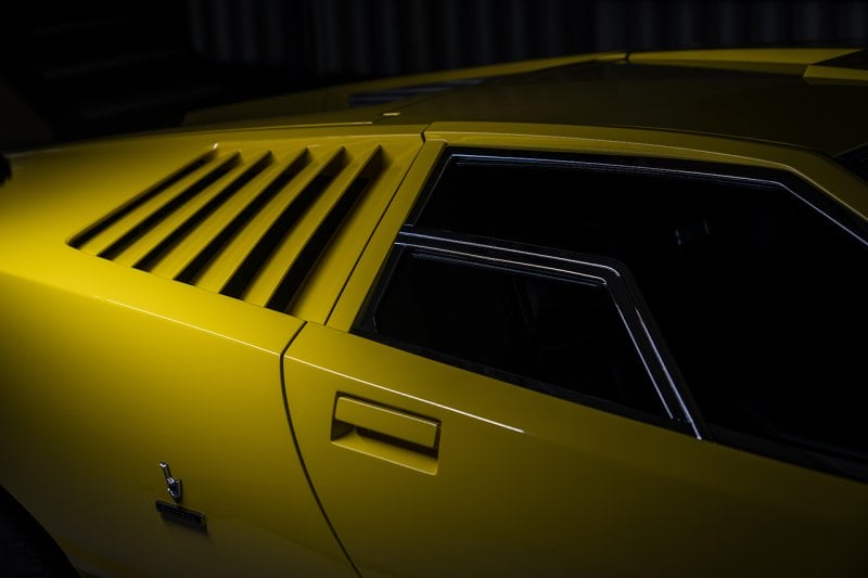 Yellow vents behind a window of a Lamborghini Countach LP400
