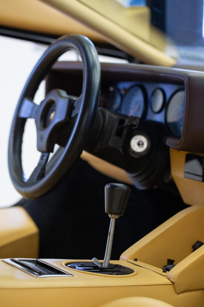tan interior with a gated manual stickshift and steering wheel of a Lamborghini