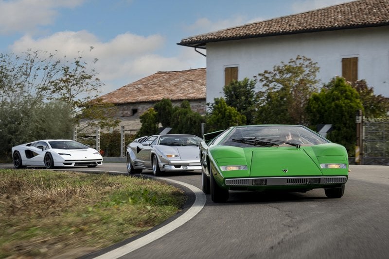 Green Countach with two other vehicles one white and grey taking a turn