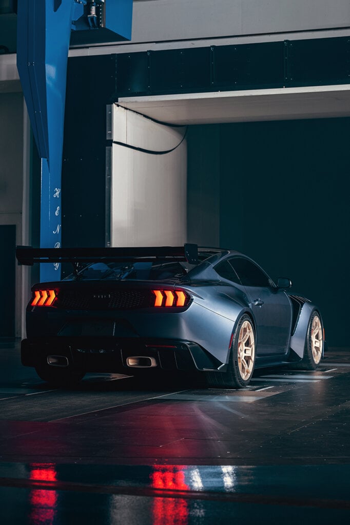 rear shot of Mustang dark and dramatic, taillights reflecting on floor in a wind tunnel