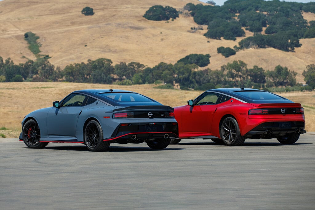 two cars blue and red next to each other mountains in the back