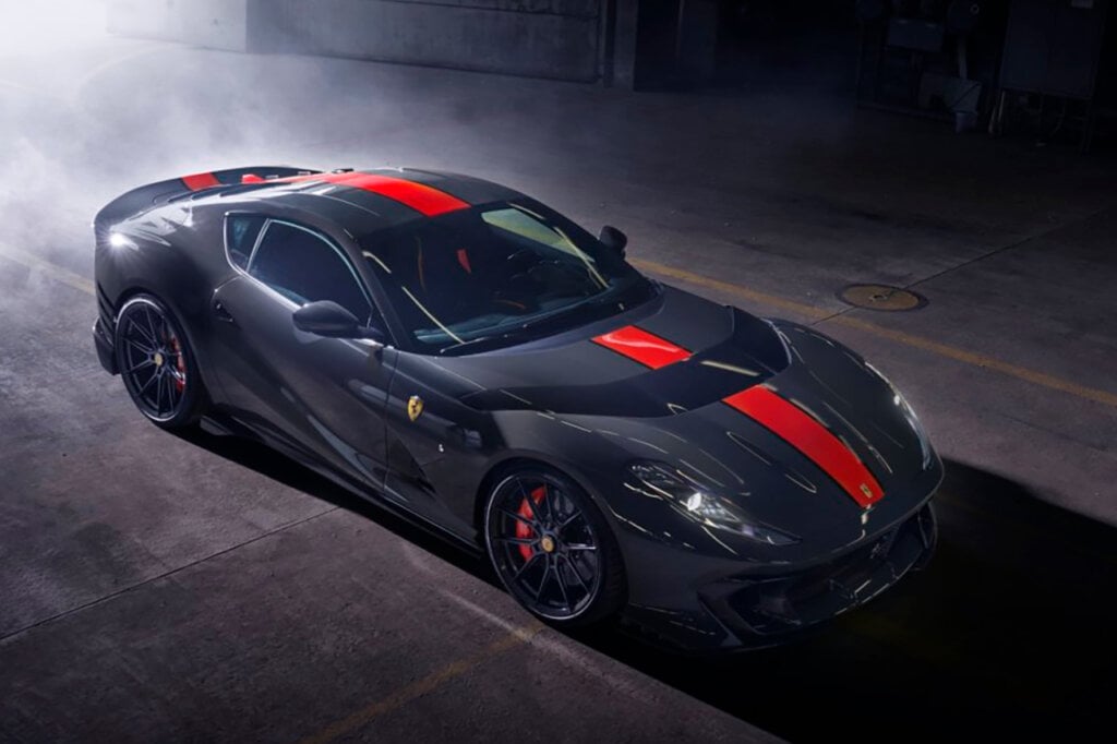 Blue grey car with red stripe in a smoky garage, dark background