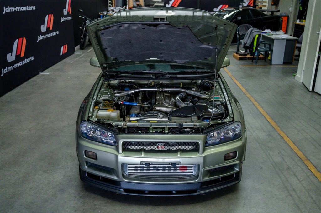 millenium jade green Nissan skyline R34 with hood propped open