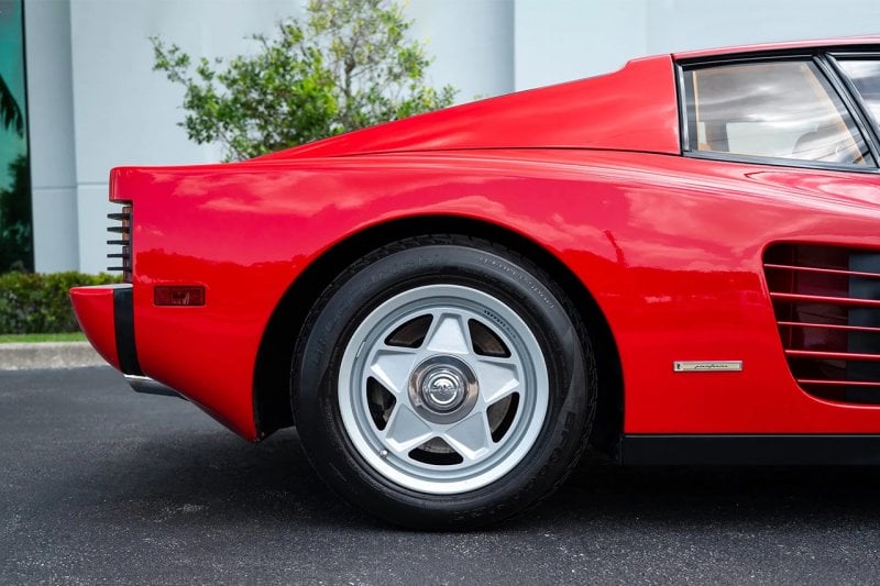 Rear wheel of a Red Ferrari Testarossa and a 5 spoke wheel