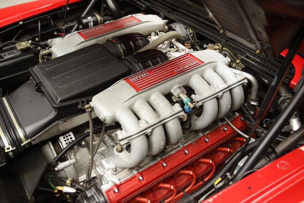4.9L Flat 12 engine. red painted valve cover underneath the intake manifold