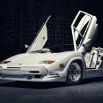 White Lamborghini Countach butterfly doors open on black background