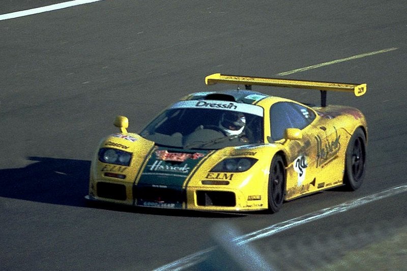 yellow and green Harrods race livery on a McLaren F1 driving fast on racetrack
