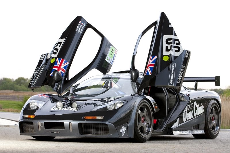 black McLaren F1 with Ueno Clinic racing livery with number 59 on it and trees in the background