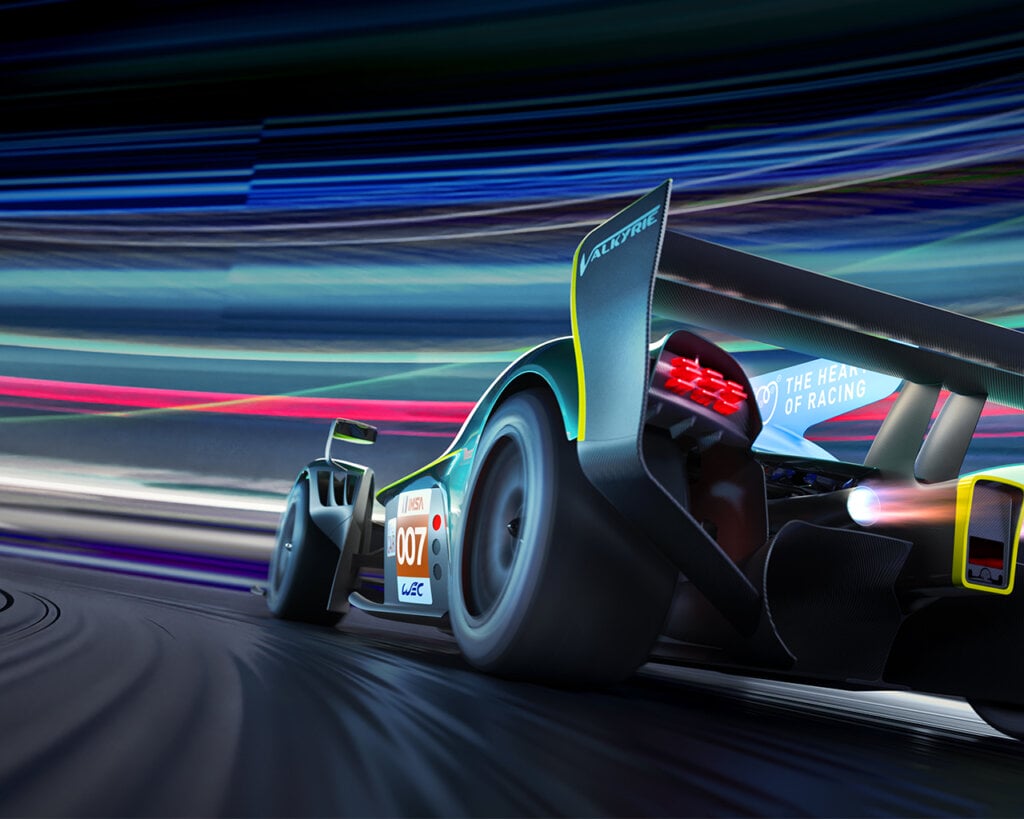 rear 3/4 quarter view of hypercar Aston Martin Valkyrie driving through a turn, streaks of colors in background