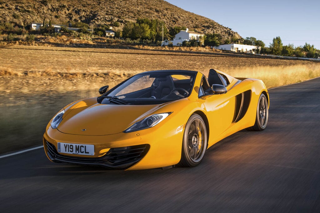 yellow mclaren 12c spider on a country road