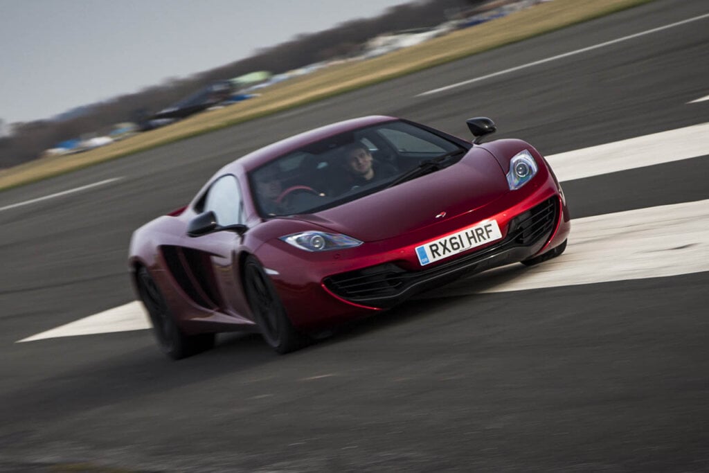 red MP4-12C speeding on a racetrack