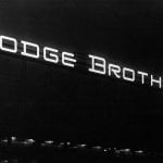 Black and white photo of a sign that says Dodge Brothers with a really dark black background