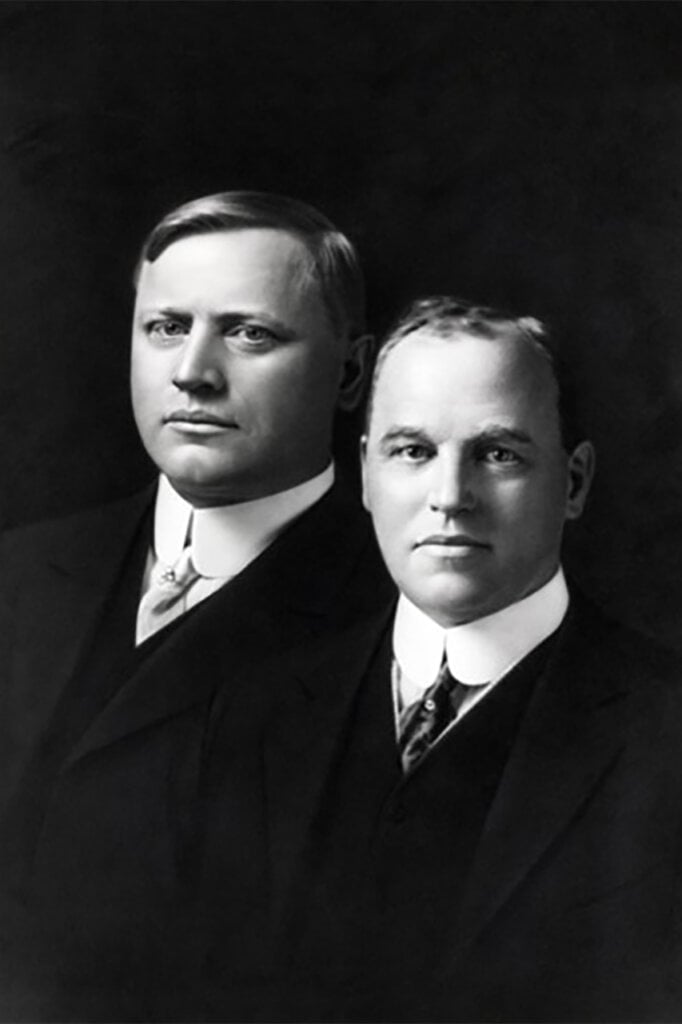 black and white photo of two men in suits next to one another